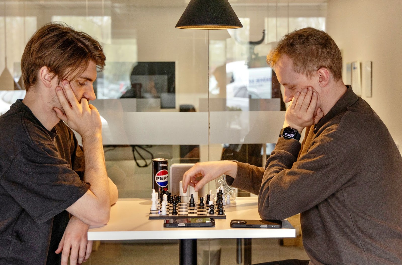 Två kollegor spelar schack i lunchrummet